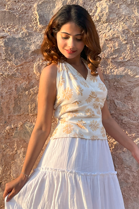 A woman is modeling a Ronazen white halter top. The top features a sleeveless design with a high neckline that ties at the back of the neck. It is fitted at the bust and flows slightly at the waist, made from a smooth, lightweight fabric. The background is neutral, emphasizing the simplicity and elegance of the top. The model stands confidently, hands on hips, showcasing the top's flattering cut and versatile style suitable for both casual and dressier occasions.